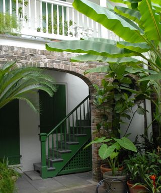 Green staircase, white banister, brick arch