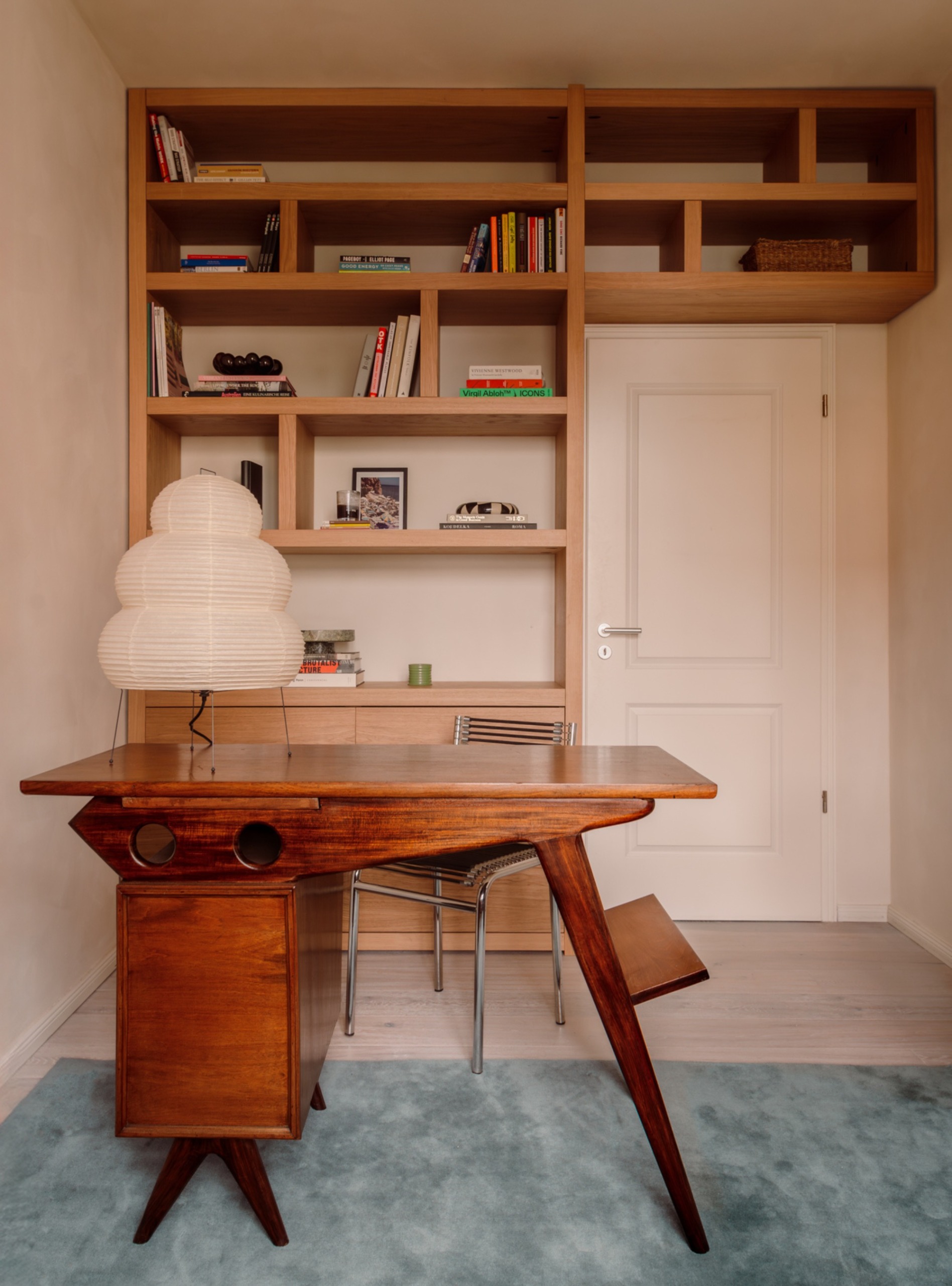 Small home office with sculptural mid century desk in the middle of the room