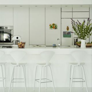 kitchen with white walls and bar stools