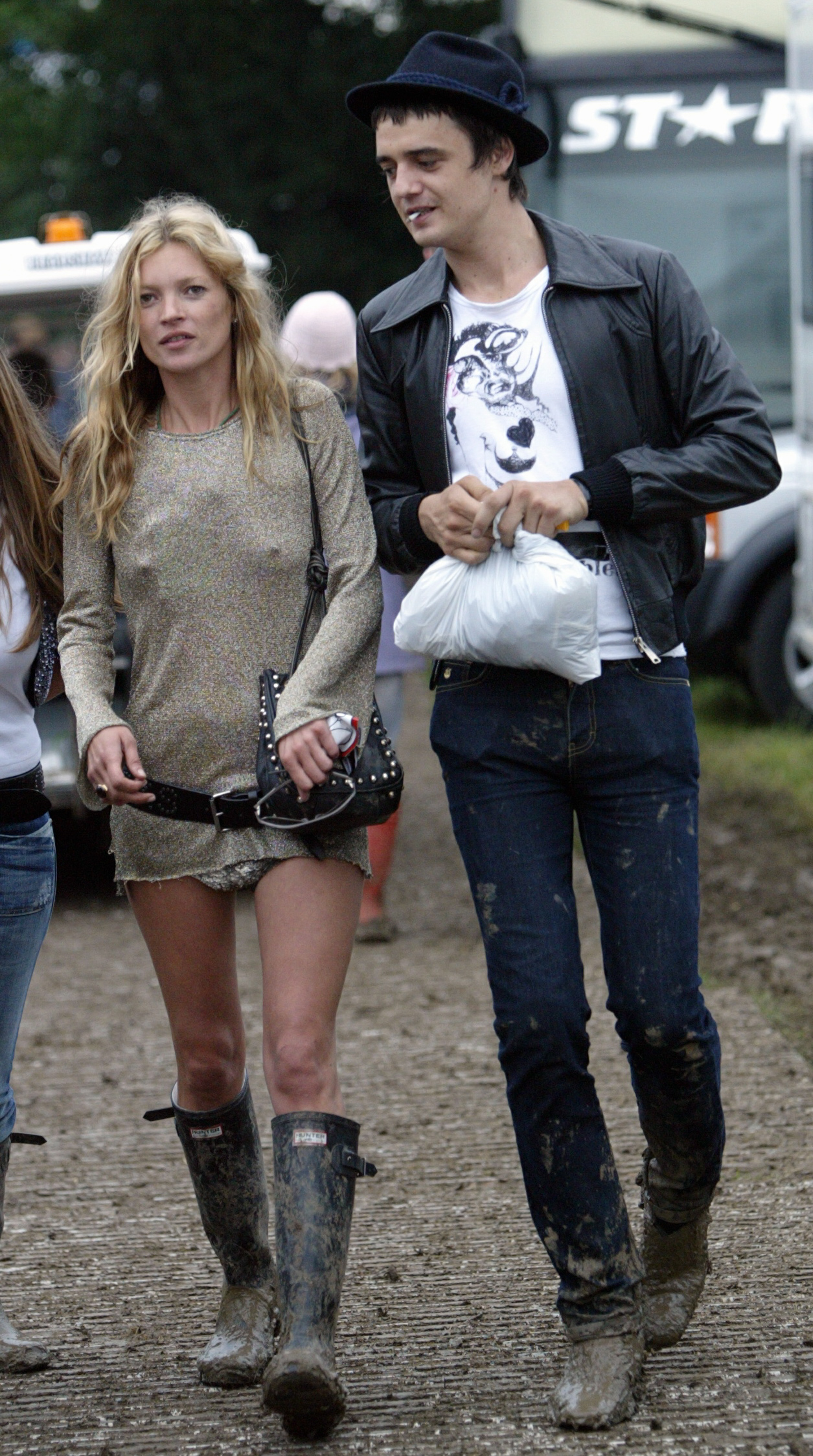 Model Kate Moss and singer Pete Doherty walk backstage during the 2005 Glastonbury Festival