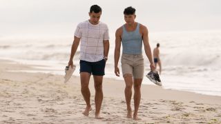 Conrad Riccamora and Joel Kim Booster walking down the beach in Fire Island