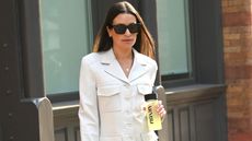 Lea Michele wearing a white suit with matching bag and shoes going to the US Open