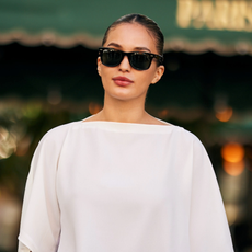 woman wearing black glasses and a white T-shirt.