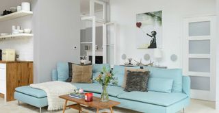 living room with a pale grey feature wall and cool white walls with duck egg blue corner sofa