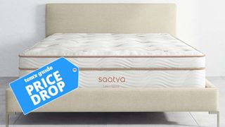 The image shows the Saatva Latex Hybrid mattress on a wooden bed frame with a Tom&#039;s Guide deal badge laid over the top