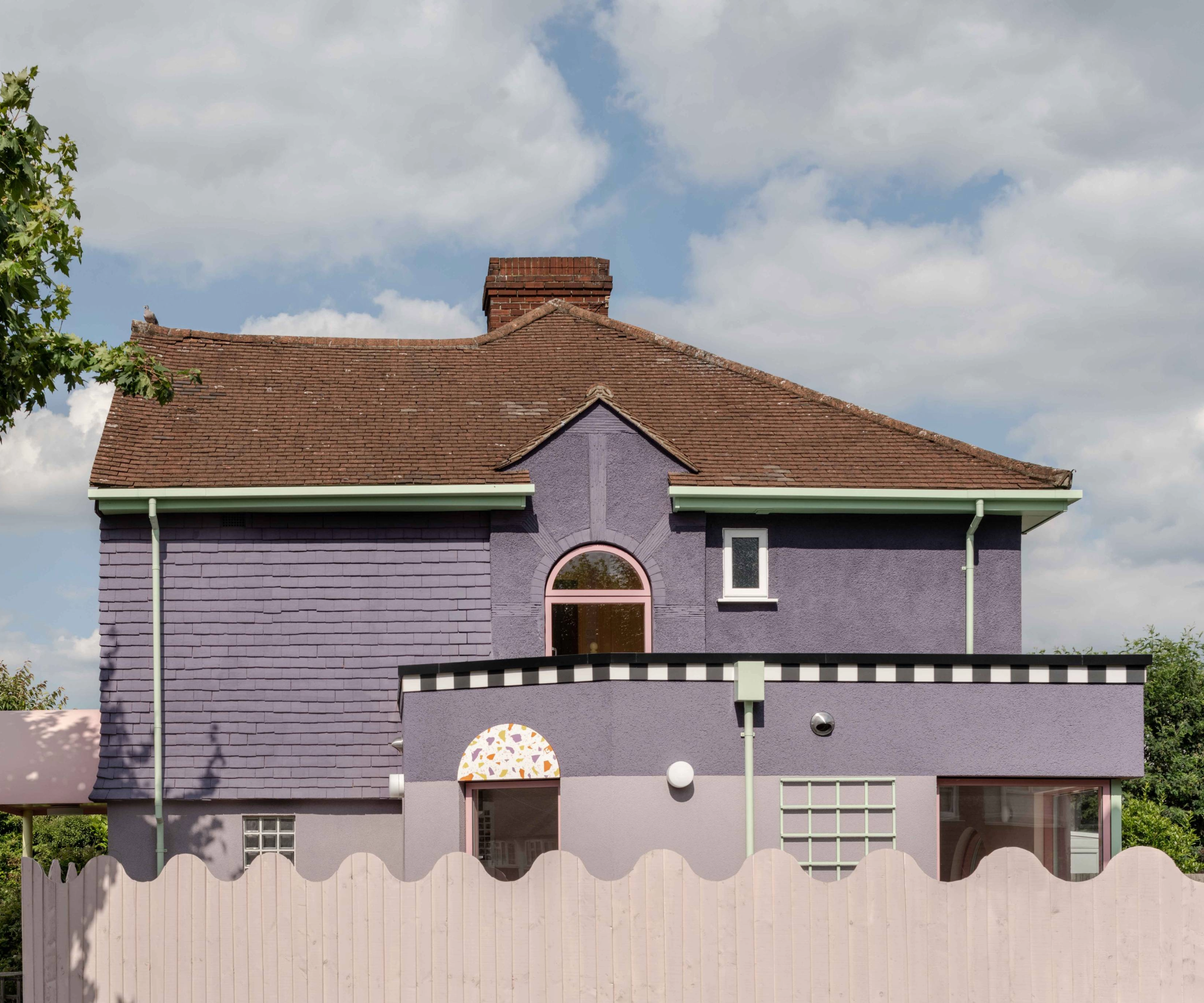Side of the house with a pink curvy fence