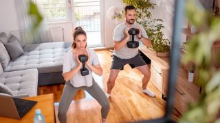 Man and woman exercise with dumbbells at home