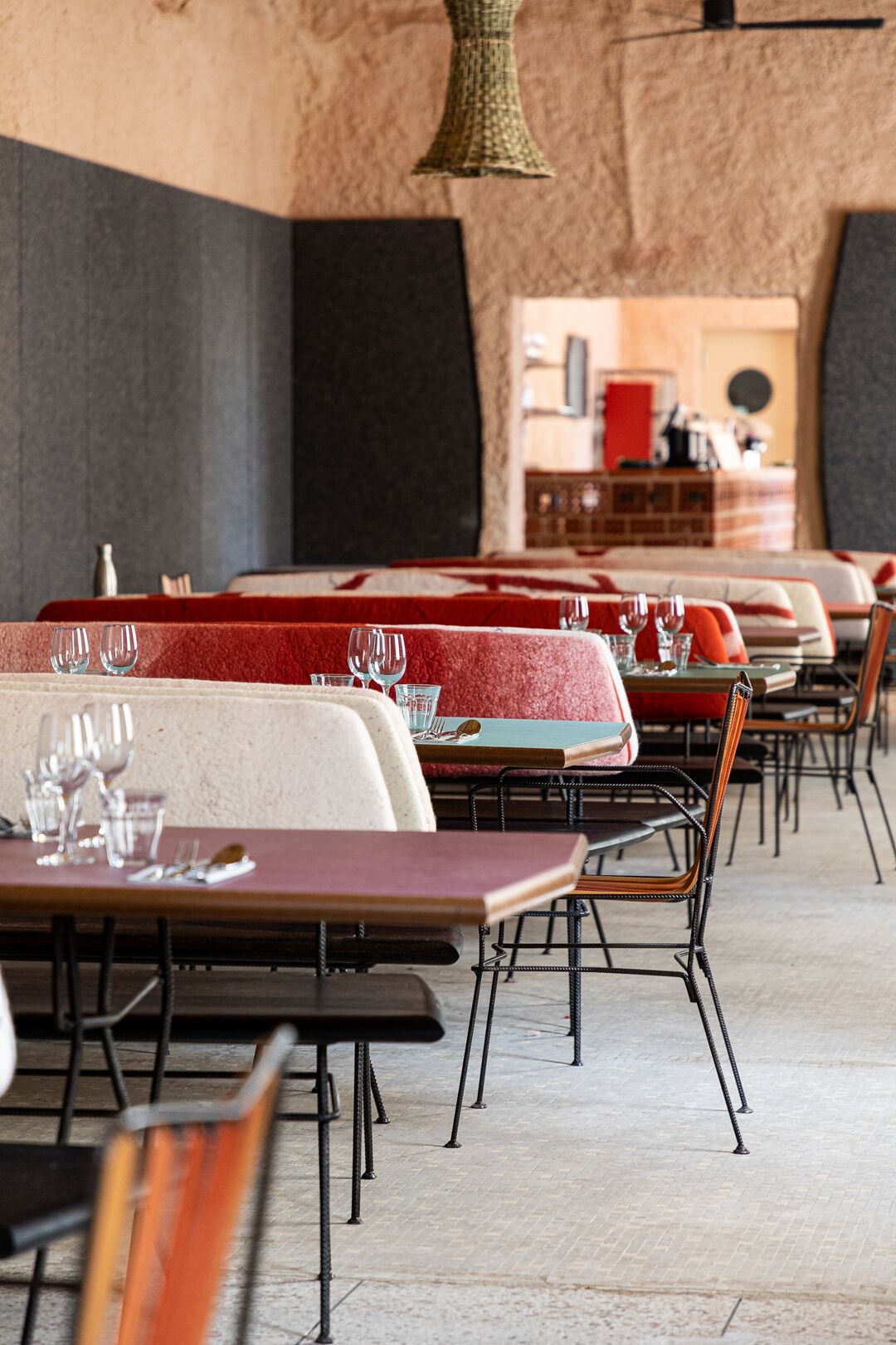 A colorful restaurant decorated with mismatched wood and iron furniture in bright hues.