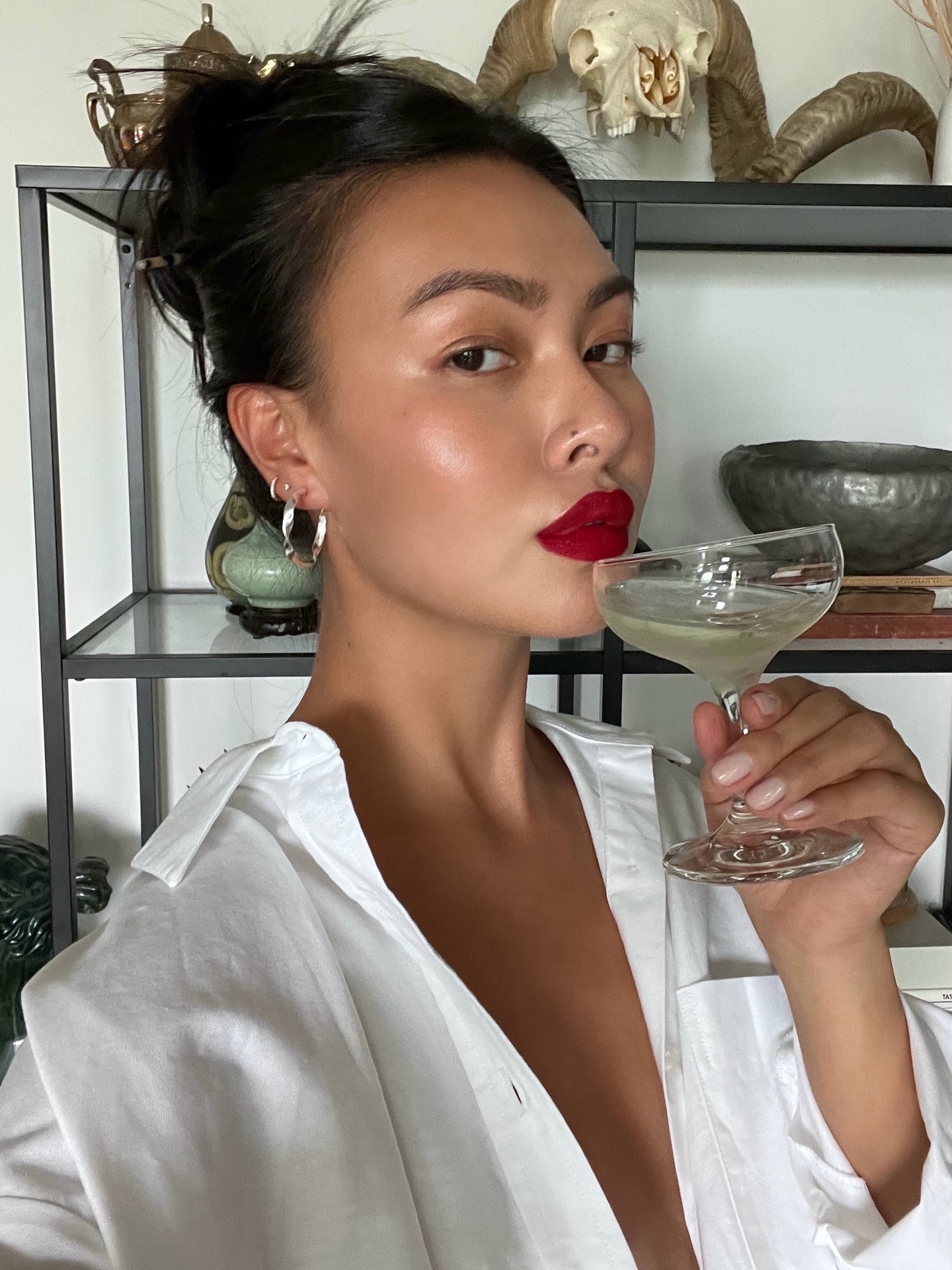 Image of a woman wearing red lipstick and sipping a martini.