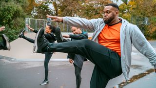 Man performing high kicks in an outdoor exercise class