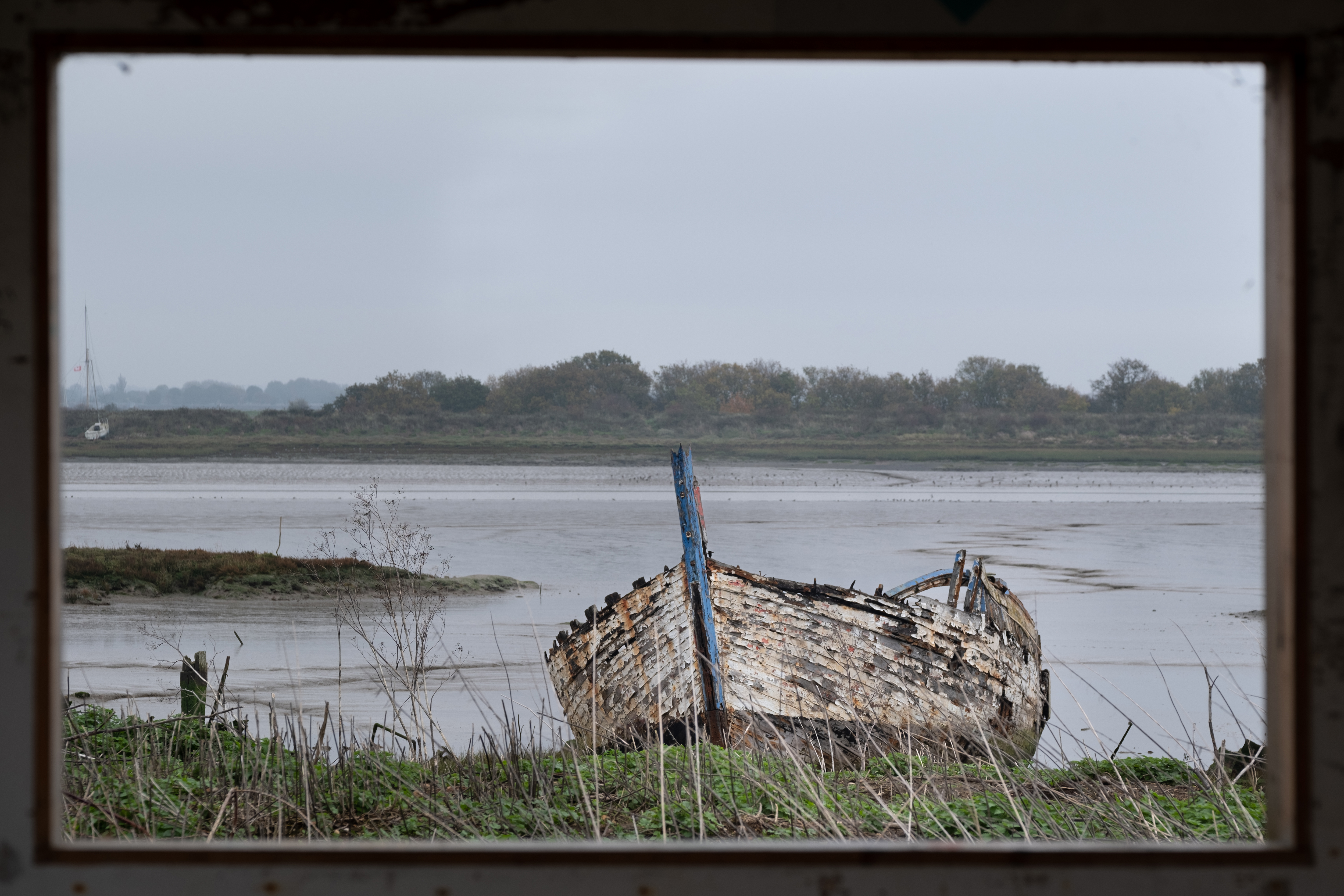 The wreck of an old boat in front of mud flats