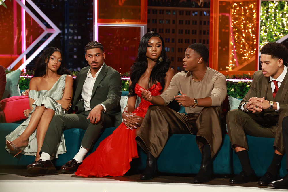 Melanie Moreno, Sincere Nicholas Rhea, Tierra Davis, Kuman Dameon &amp;ldquo;KC&amp;rdquo; Chandler, Sean David Reifel, and Corbin Mims sit on a teal couch at the love island usa season 8 reunion