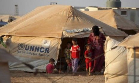 A Syrian refugee and her children at the entrance to their tent in the Zaatari Syrian refugee camp, in Mafraq, Jordan: Jordan is host to the largest number of Syrian refugees at 142,000, incl