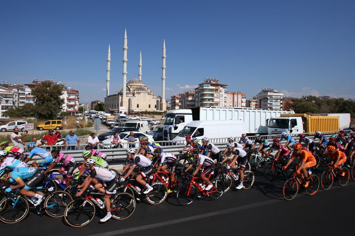 The riders pass by a mosque