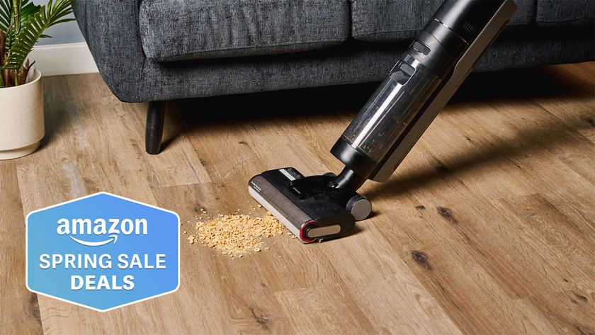 a photograph of the dreame h12 pro wet and dry vacuum cleaner cleaning up spilled cheerios on a hardwood floor with an amazon spring sales deals badge