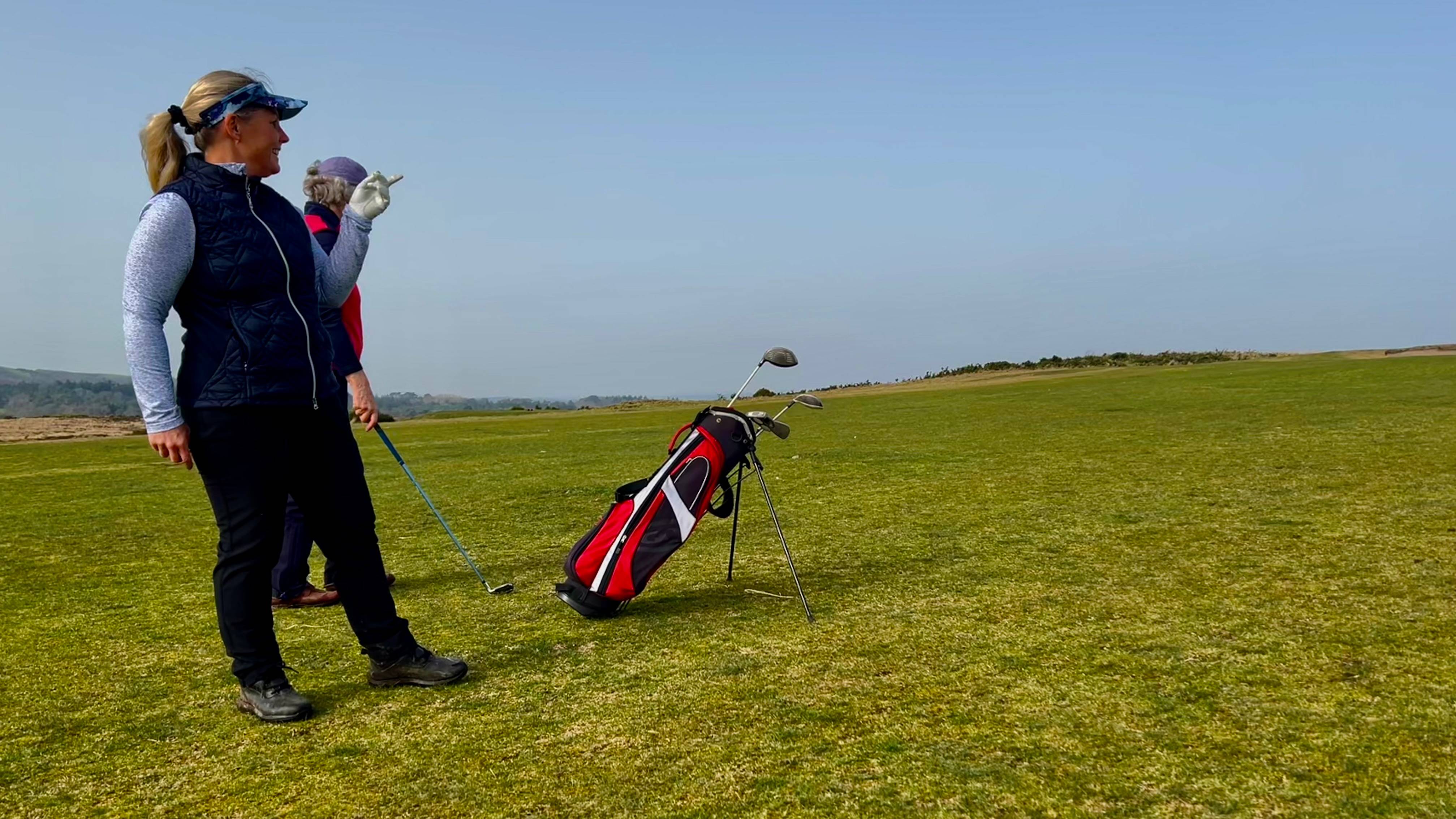 Carly Cummins giving advice to a beginner golfer