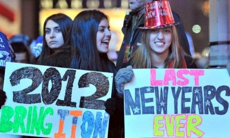 A New Year&amp;#039;s eve reveler holds up a doomsday-inspired sign