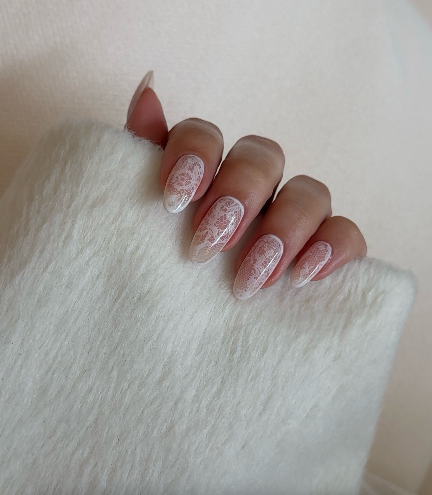 A white lace manicure on almond-shaped nails