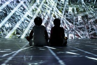 Two kids sit immersed in projection mapping thanks to the Green Hippo Hippotizer.
