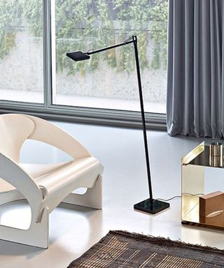 Flos Kevin Floor Lamp in bright living room beside white arm chair and mirrored side table