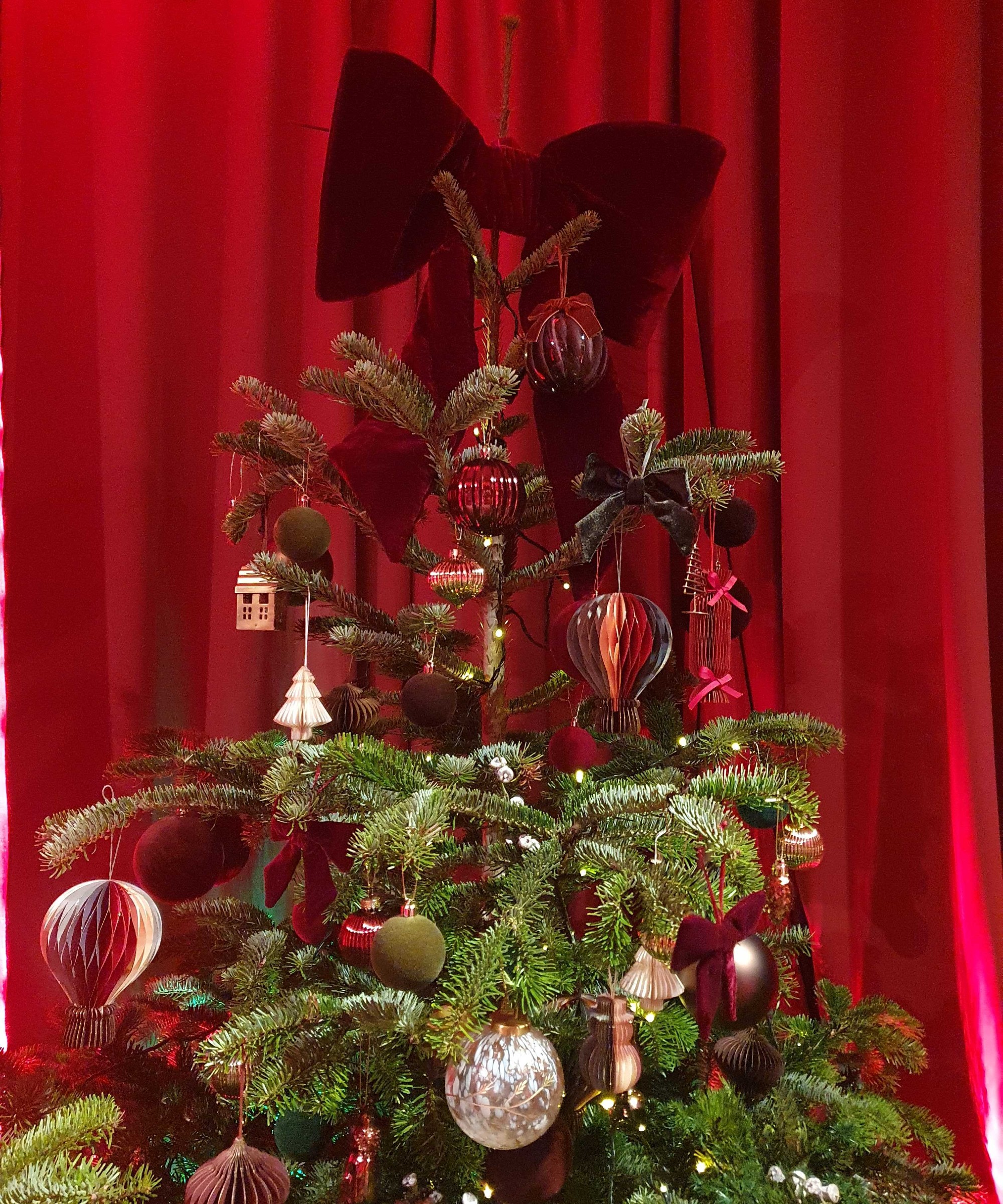 Marks &amp;amp; Spencer's large red velvet Christmas bow used as a tree topper at the brand's autumn/winter 2026 press preview