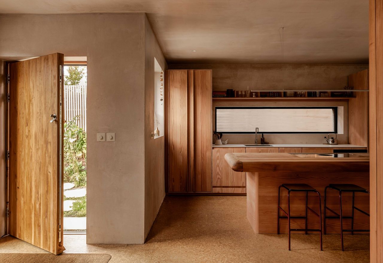 kitchen with limewash walls, cork flooring, timber kitchen cabinetry, reclaimed timber countertop