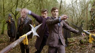 The Tenth and Eleventh Doctors with sonic screwdrivers drawn being threatened with halberds in the Doctor Who episode "The Day of the Doctor"