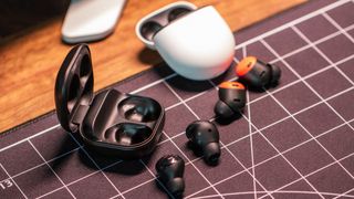 Google Pixel Buds Pro vs. Galaxy Buds Pro in front of cases left angle