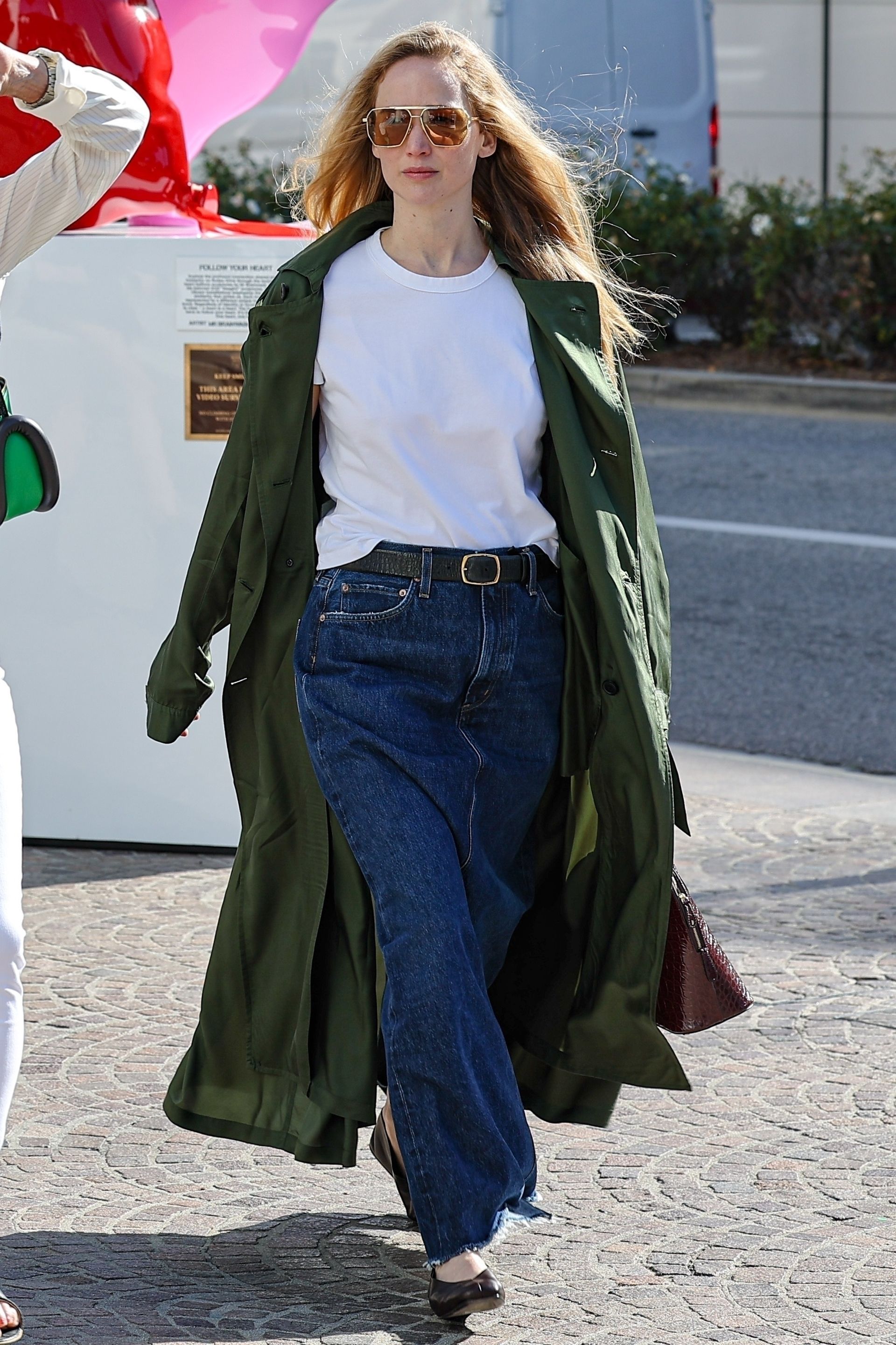 Jennifer Lawrence spotted in Los Angeles wearing a green jacket, white tee, and long denim skirt.
