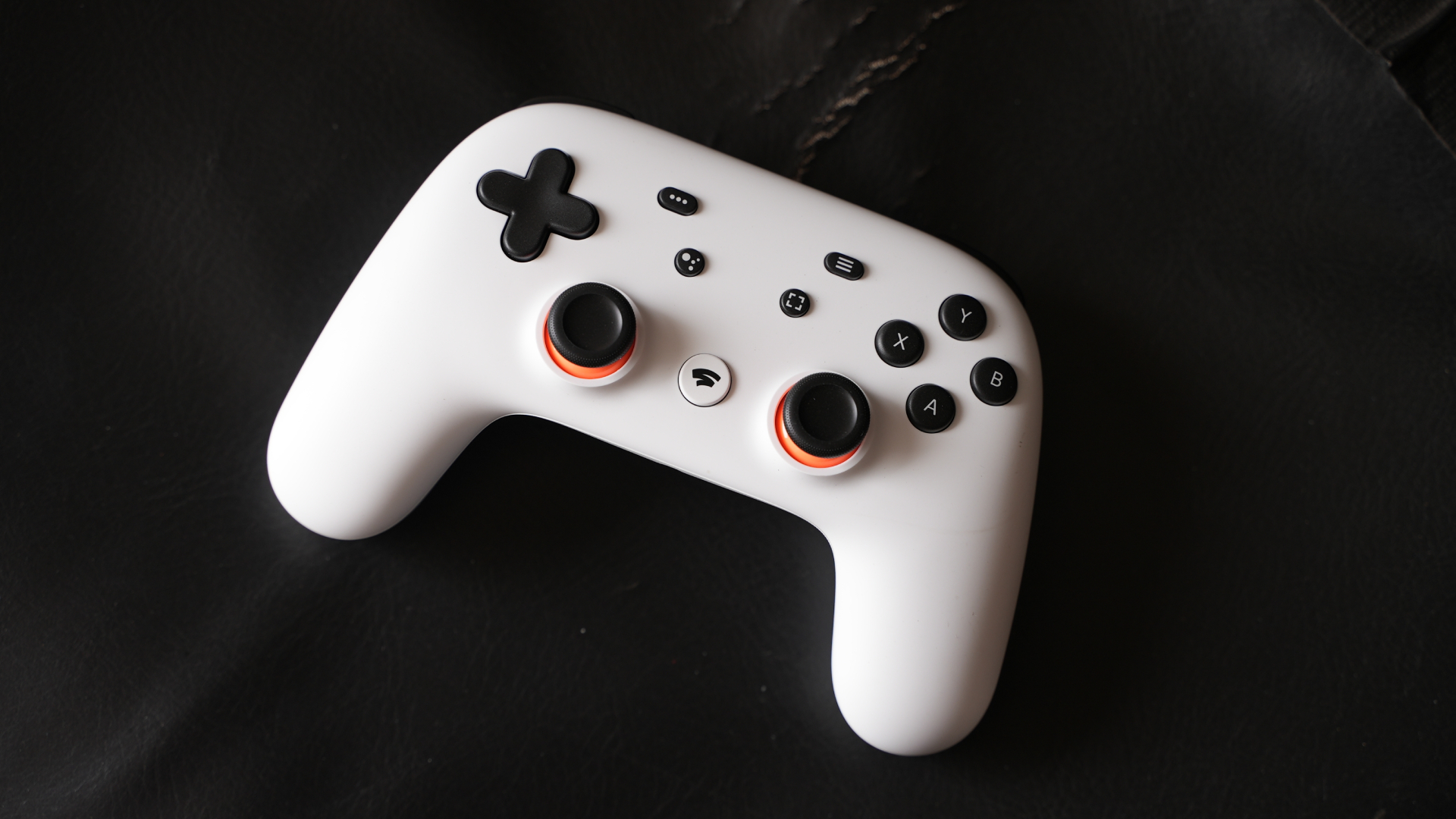 The Google Stadia controller sits on a black surface