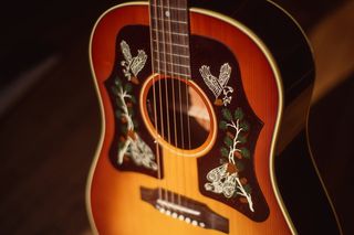 A close-up of the double pickguard on Margo Price's J-45, showing the red-tailed hawk inlays