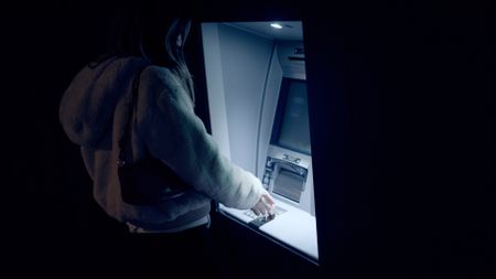 person using ATM at night