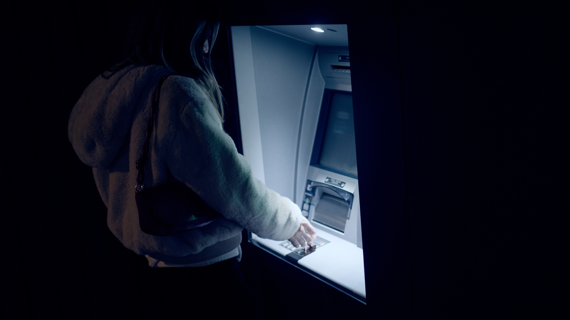 person using ATM at night