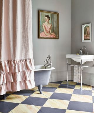 Bathroom with pink shower curtain, checked floor, painted, pale grey walls, artwork