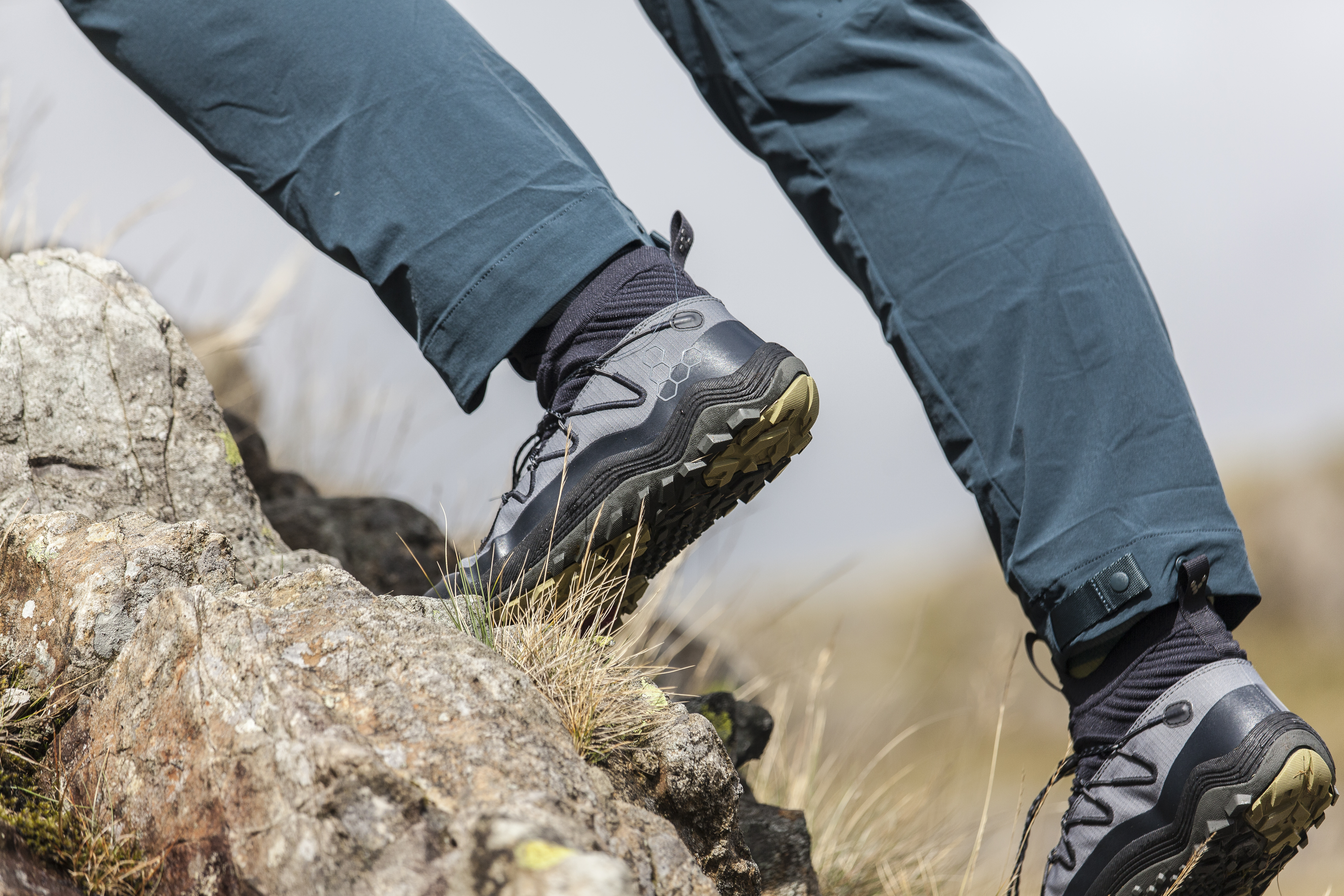 Woman wearing Vivobarefoot Primus Flow Mid hiking boots and scrambling in them