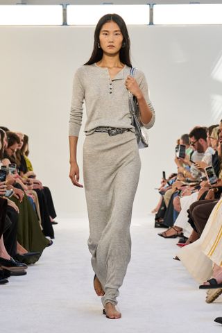 An S/S 25 model wearing layered belts on a jersey maxi dress at the Brandon Maxwell show.