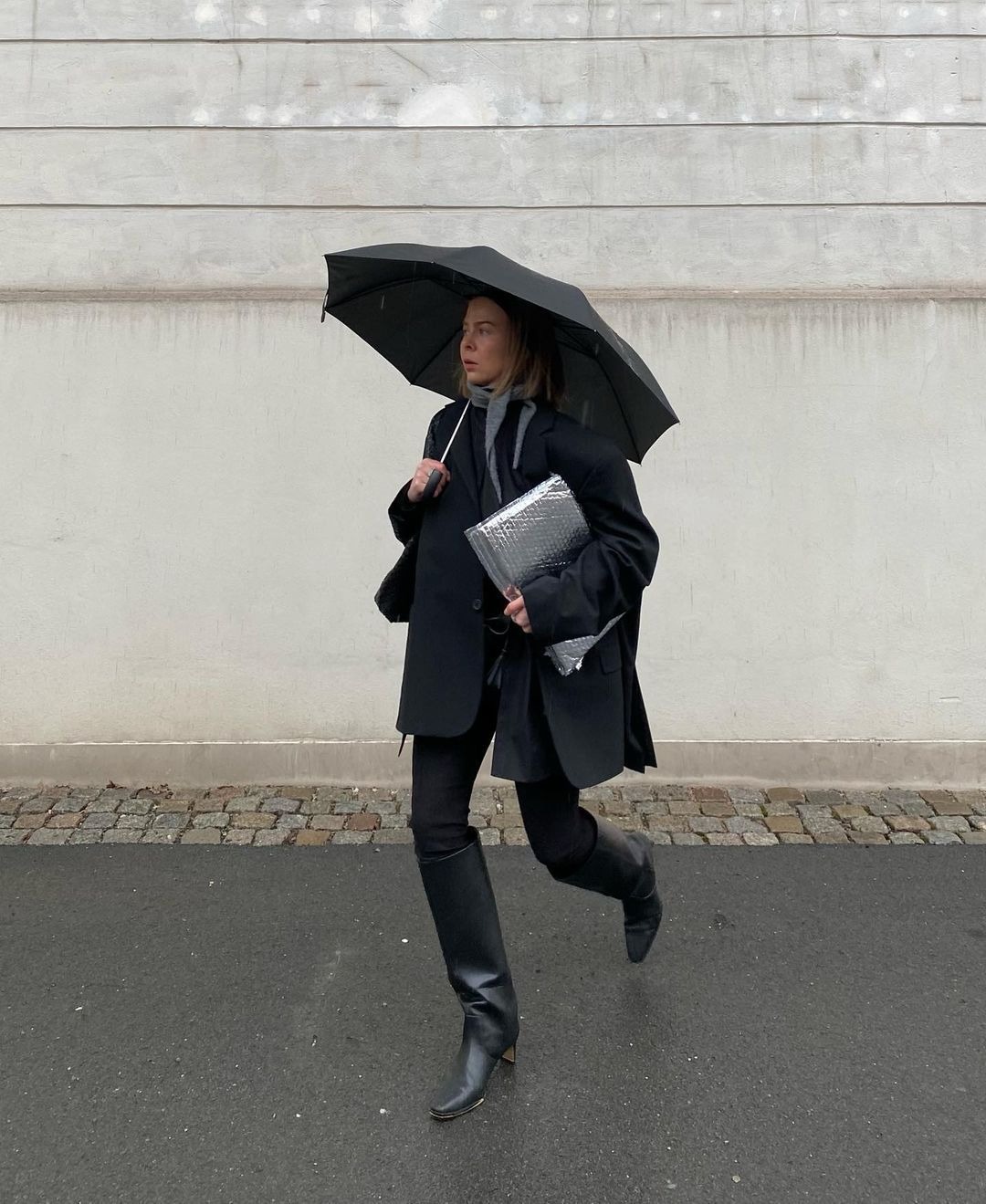 @dinahansen in the rain holding an umbrella