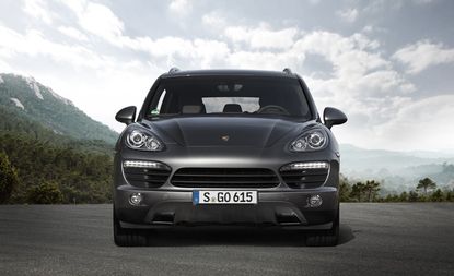 Front view of a black Porsche Cayenne S Diesel with trees in the background