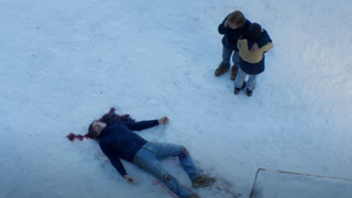 Still from Anatomy of a Fall showing two people looking on in horror at a dead man on a snowy floor