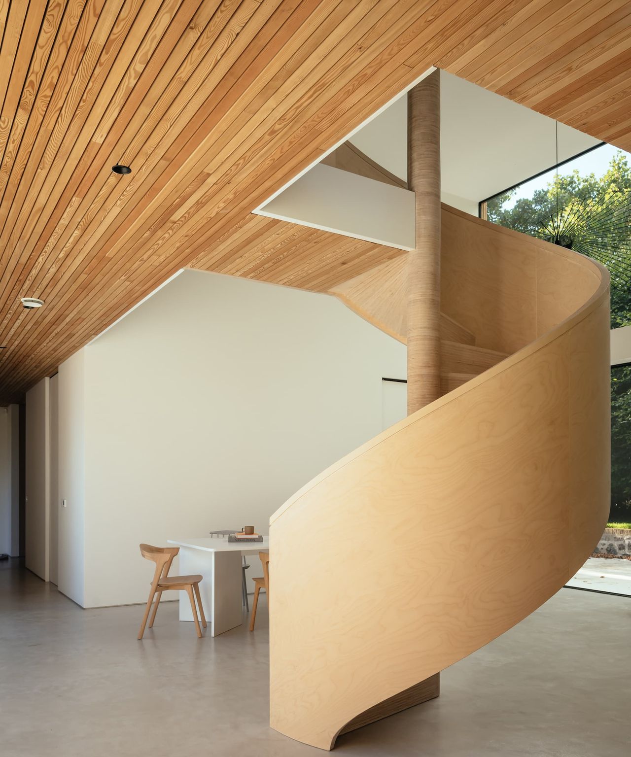 A curved wooden staircase with a central pillar