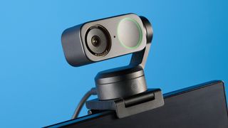 Insta360 Link 2 Pro in graphite black attached to a computer screen photographed on a blue background