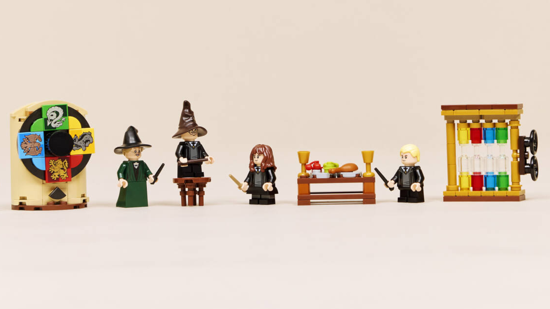 Wizard and witch minifigures spread out across a pink environment, full of accessories