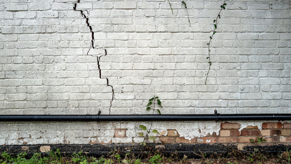 White brick cottage wall with large crack caused by subsidence