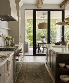 large kitchen with flowers in a vase on the counter and big windows looking out to the patio