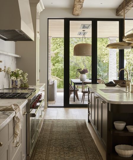 large kitchen with flowers in a vase on the counter and big windows looking out to the patio
