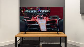 LG C4 42-inch OLED TV on wooden TV rack with F1 car on screen