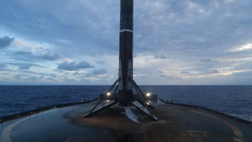 A sooty booster stands on 4 legs on a barge at sea.