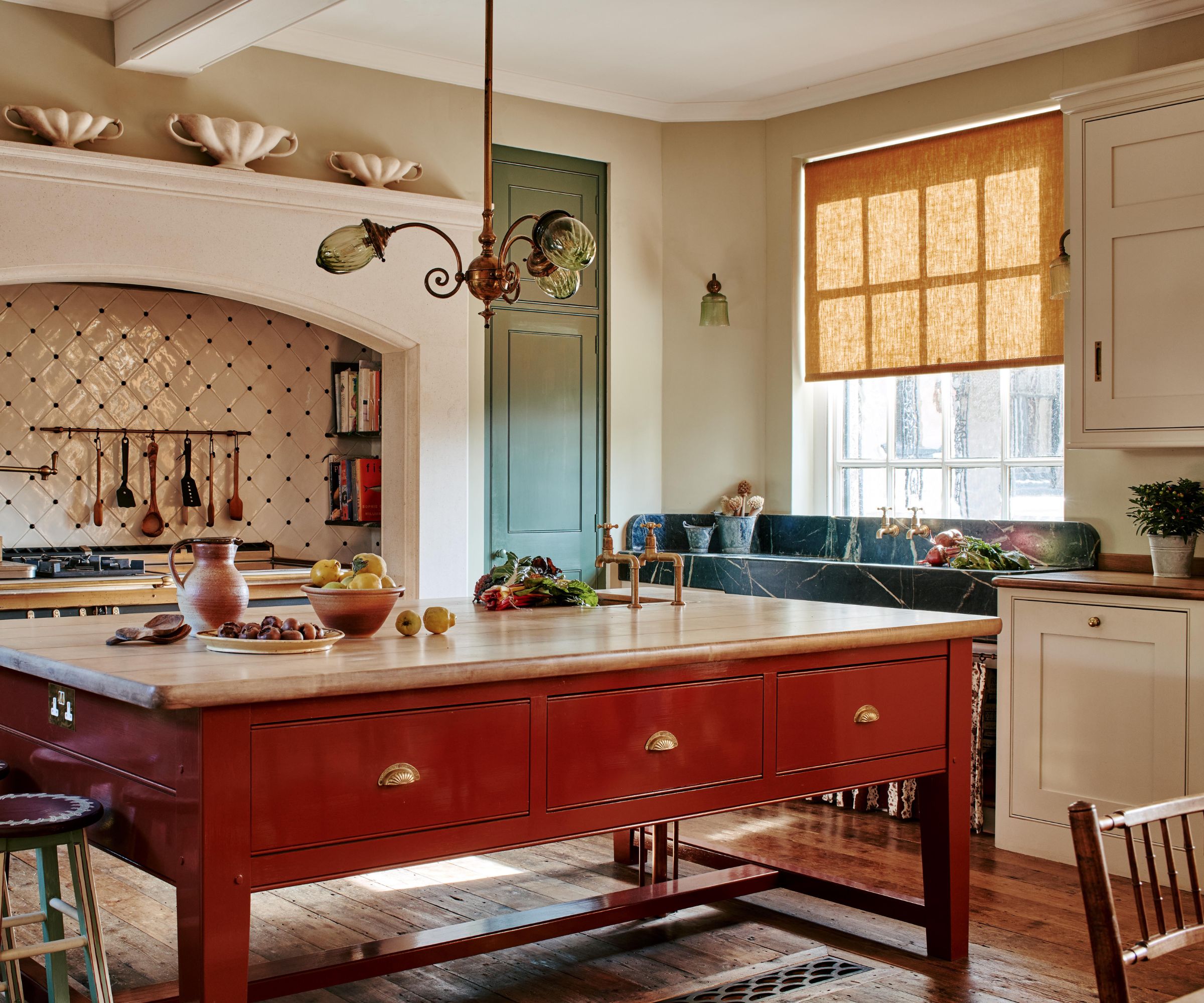 A traditional kitchen with white cabinets and a terracotta red kitchen island