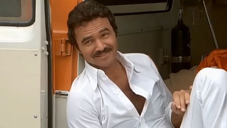 Burt Reynolds in all white, smiling in The Cannonball Run