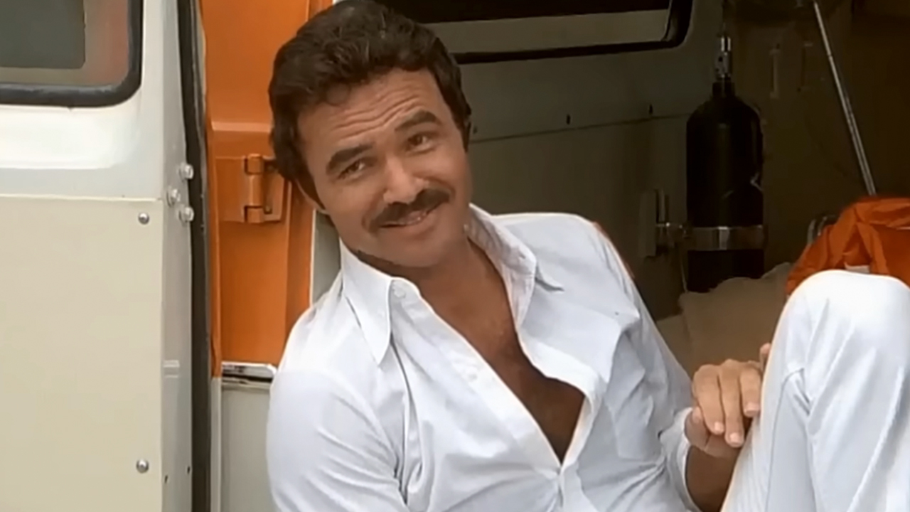 Burt Reynolds in all white, smiling in The Cannonball Run